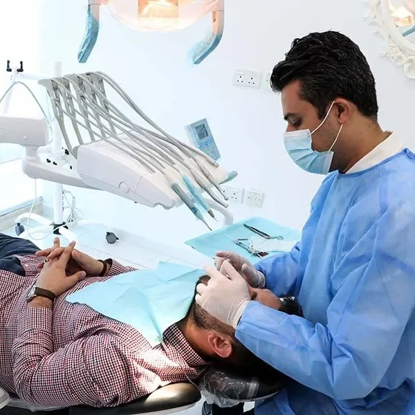 Luxury dental clinic in Dubai showing modern treatment room with advanced equipment, comfortable patient chairs, and professional dental team at Queens Medical Center